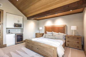 Carpeted bedroom with wine cooler, wooden ceiling, lofted ceiling, and indoor wet bar