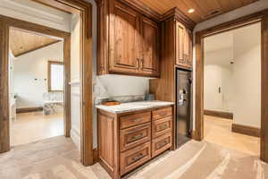 Interior space featuring light carpet, wood ceiling, and light stone counters