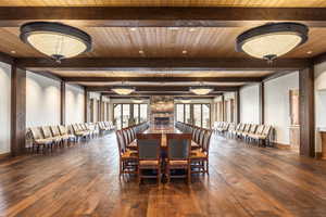 Dining room with beam ceiling, dark hardwood / wood-style flooring, and wood ceiling