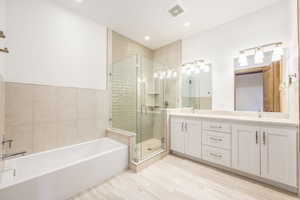 Bathroom with plus walk in shower, vanity, and tile walls