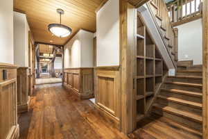 Corridor featuring dark hardwood / wood-style flooring, wood ceiling, and ornamental molding