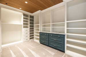 Walk in closet featuring light colored carpet