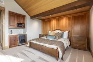 Carpeted bedroom featuring lofted ceiling, wet bar, wooden ceiling, and wine cooler