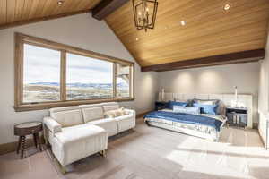 Carpeted bedroom with lofted ceiling with beams, a mountain view, wood ceiling, and a notable chandelier