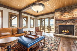 Living room featuring hardwood / wood-style floors, wood ceiling, and a fireplace