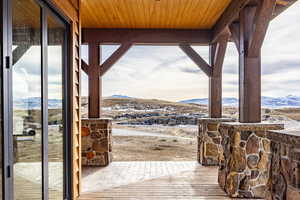 Entryway with a mountain view, light wood-type flooring, and wooden ceiling