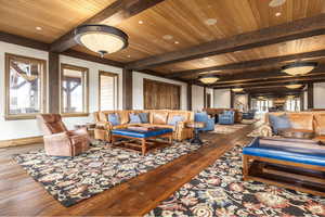 Living room featuring beamed ceiling, wooden ceiling, and hardwood / wood-style flooring