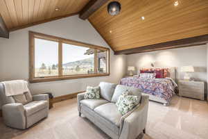 Bedroom featuring a mountain view, lofted ceiling with beams, light colored carpet, and wood ceiling