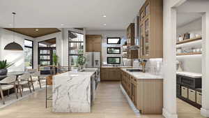 Kitchen with light stone counters, plenty of natural light, hanging light fixtures, and light hardwood / wood-style floors