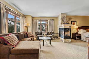 Living room with a healthy amount of sunlight, carpet floors, and a tile fireplace