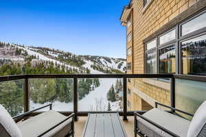 Snow covered back of property with a mountain view