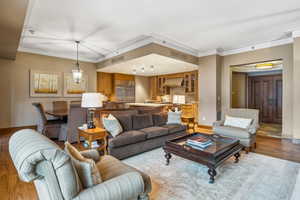 Living room with light hardwood / wood-style floors and ornamental molding