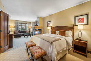 Carpeted bedroom featuring a multi sided fireplace