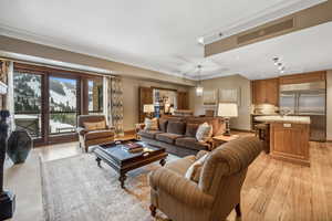 Living room with light wood-type flooring and crown molding