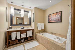 Bathroom with tiled tub and vanity