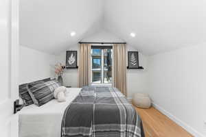 Bedroom featuring wood-type flooring and vaulted ceiling