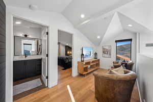 Sitting room featuring lofted ceiling, sink, and light hardwood / wood-style flooring