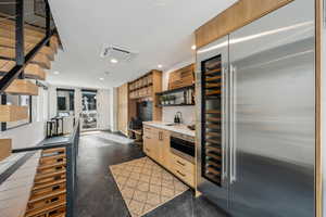 Kitchen with stainless steel built in refrigerator, light brown cabinetry, and sink