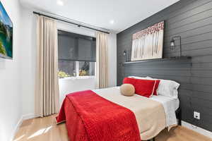 Bedroom featuring wood walls and light hardwood / wood-style flooring