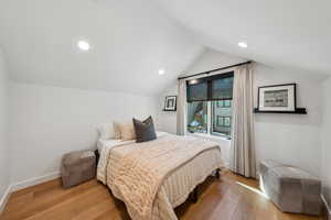 Bedroom with vaulted ceiling and light hardwood / wood-style flooring