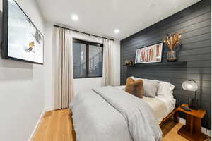 Bedroom featuring wooden walls and light wood-type flooring