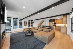 Living room with beamed ceiling and light hardwood / wood-style flooring