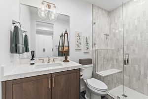 Bathroom with an enclosed shower, vanity, and toilet