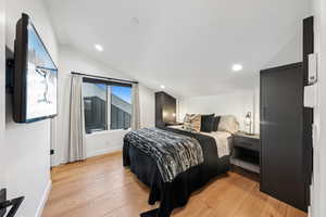 Bedroom featuring vaulted ceiling and light wood-type flooring