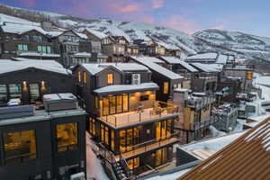 Snow covered back of property with a mountain view