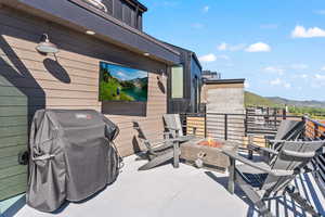 View of patio featuring a fire pit, a mountain view, and area for grilling