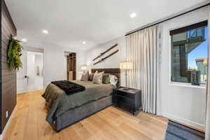 Bedroom featuring ensuite bathroom and light hardwood / wood-style flooring