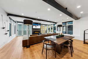 Dining room featuring beam ceiling, plenty of natural light, and light hardwood / wood-style floors