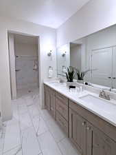 Bathroom with vanity and tiled shower