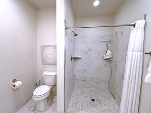 Bathroom featuring a shower with curtain and toilet