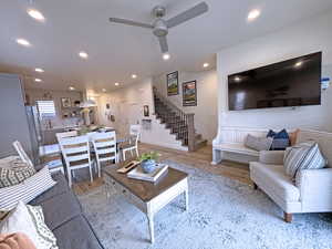 Living room with ceiling fan and light hardwood / wood-style flooring