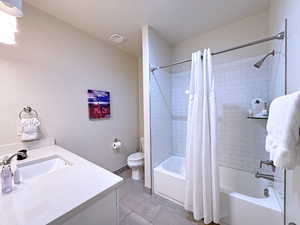 Full bathroom with tile patterned floors, vanity, toilet, and shower / bath combo