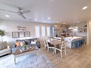 Living room with ceiling fan and light hardwood / wood-style floors