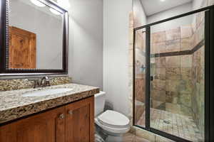 Bathroom featuring tile patterned floors, vanity, toilet, and an enclosed shower