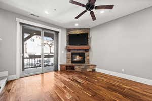 Unfurnished living room with ceiling fan, a fireplace, and hardwood / wood-style flooring