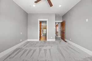 Unfurnished bedroom featuring light colored carpet and ceiling fan