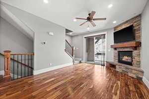 Unfurnished living room featuring a fireplace, hardwood / wood-style floors, and ceiling fan