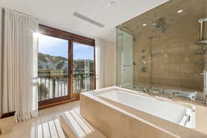 Bathroom featuring tile patterned flooring, shower with separate bathtub, and a mountain view