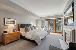 Bedroom featuring carpet flooring, crown molding, and a fireplace