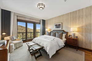 Bedroom with a mountain view, ornamental molding, and hardwood / wood-style flooring