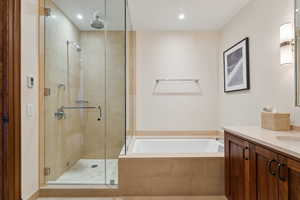 Bathroom featuring vanity and shower with separate bathtub