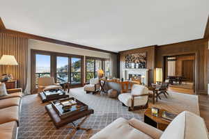 Living room featuring wood walls, crown molding, and hardwood / wood-style flooring