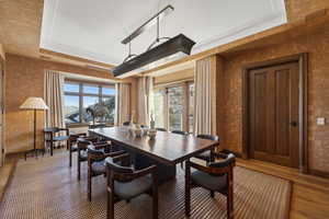 Dining room featuring hardwood / wood-style floors, a tray ceiling, and plenty of natural light