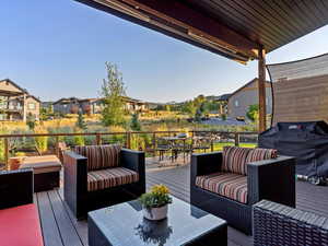 Wooden deck with an outdoor living space and grilling area