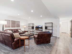 Living room with light hardwood / wood-style floors and a barn door