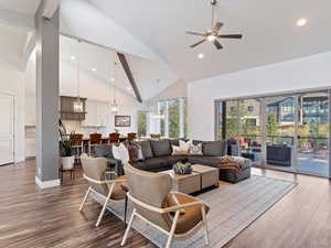 Living room with hardwood / wood-style floors, ceiling fan, and high vaulted ceiling